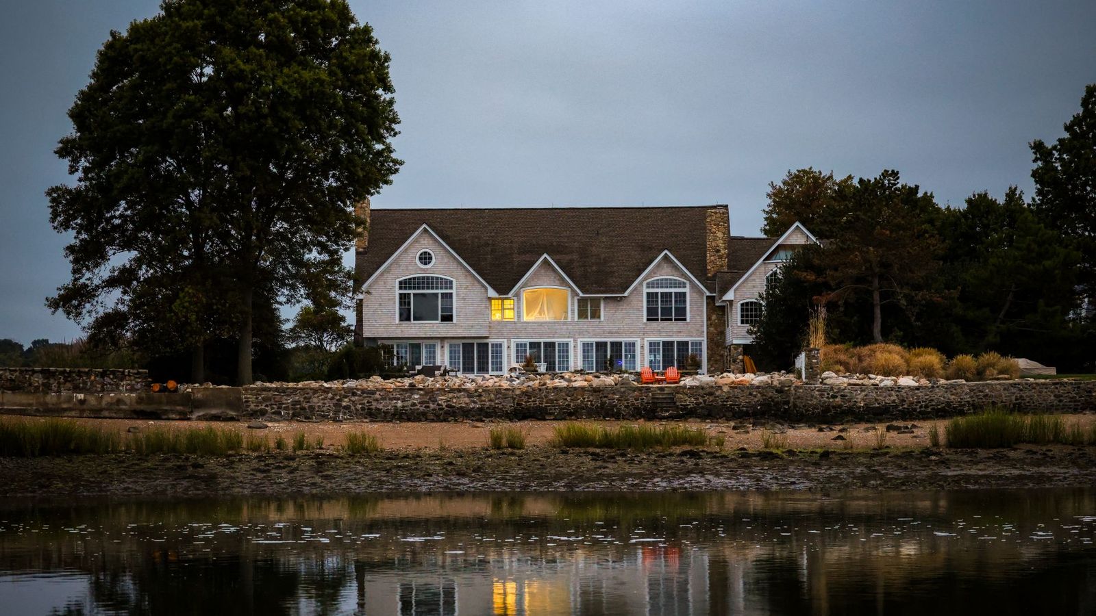 New England waterfront home by calm water, representative of Shippan, Stamford CT
