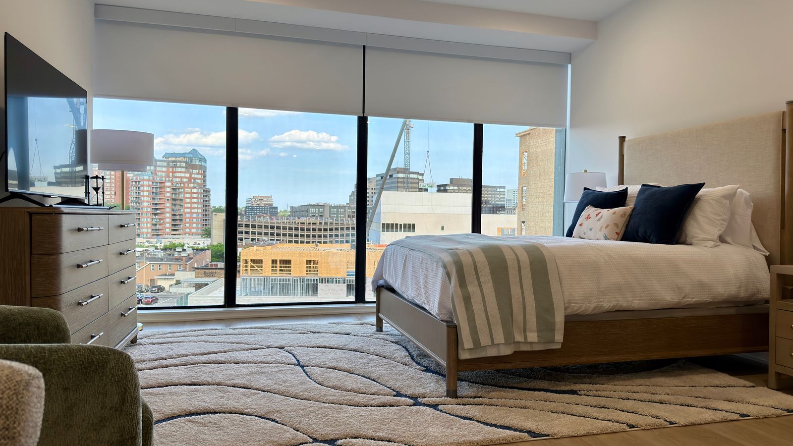 Primary bedroom in a downtown Stamford condo with skyline views through floor-to-ceiling glass