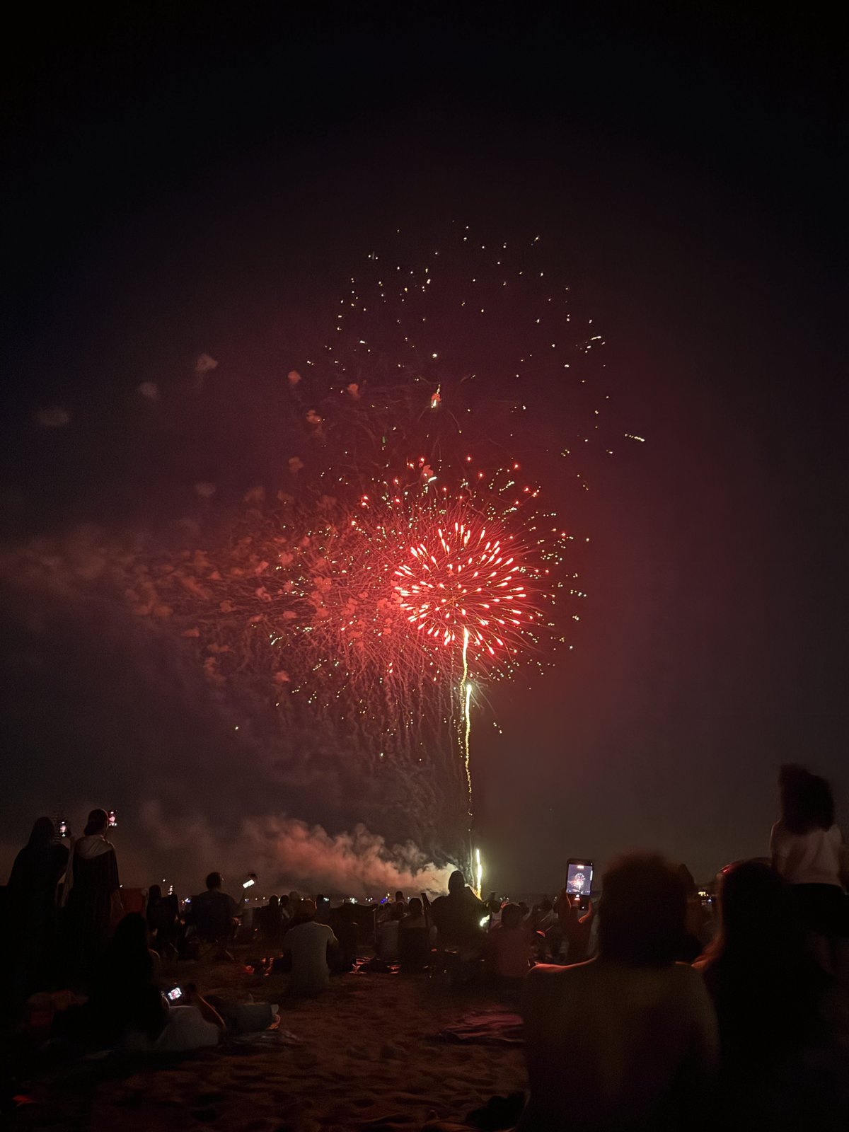Fourth of July fireworks bursting red over the crowd at the Stamford, CT waterfront