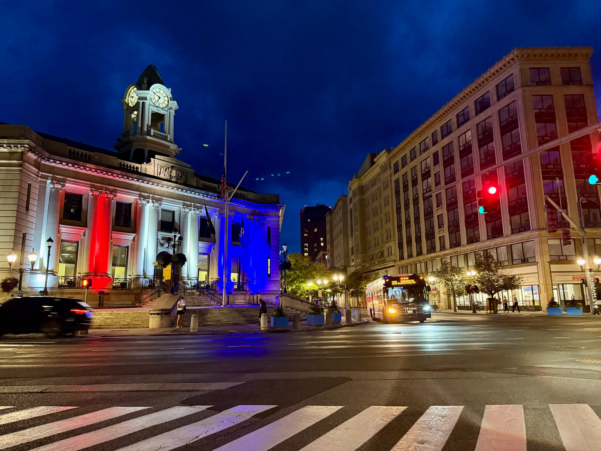 A cityscape with illuminated buildings and traffic lights in Downtown Stamford, CT